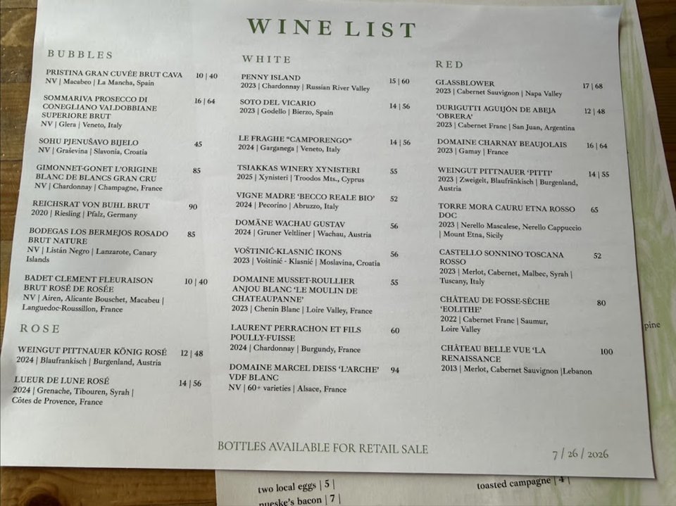 Printed menu beside a wine glass.